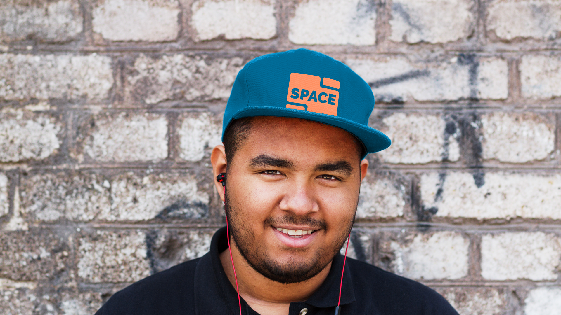 A photo of someone wearing a snap-back hat with the Space logo printed on it.